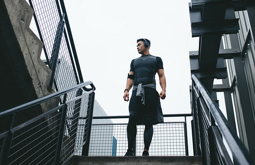 Fitness man standing on the steps outside