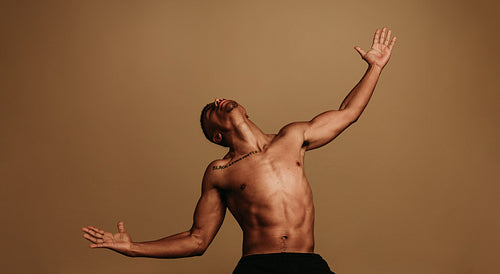 Portrait of muscular man with stretched arms