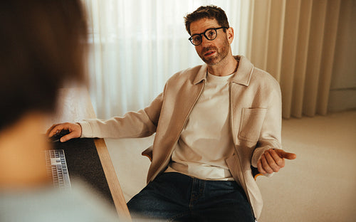 Business man talks while sitting on a desk in a creative office 
