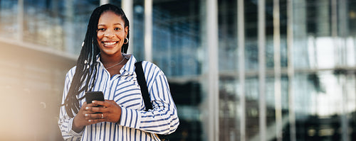 Happy young businesswoman smiling at the camera while commuting in the city