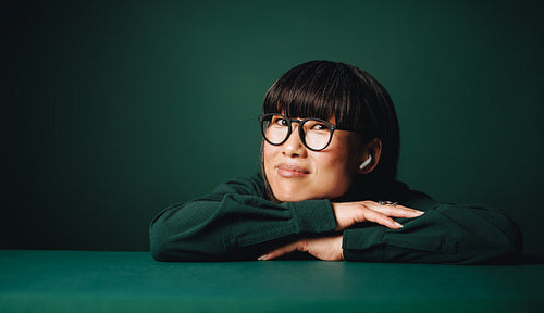 Audio defines the earbuds in a relaxed studio portrait with glasses