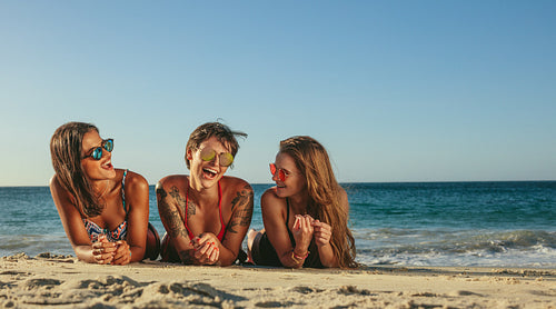 Woman friends relaxing at the beach and talking