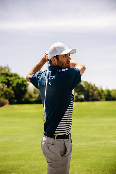 Male golf player executing a powerful swing on the fairway in a close-up shot