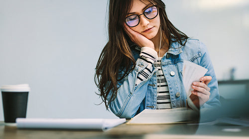 Girl reading a book at college library