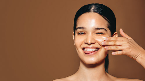 Woman in her 20’s applying facial cream as part of her daily routine