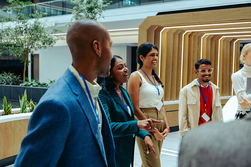 Finance professionals engaging in a lively discussion in a modern office lobby
