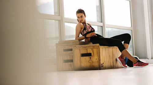 Female athlete resting after workout at gym