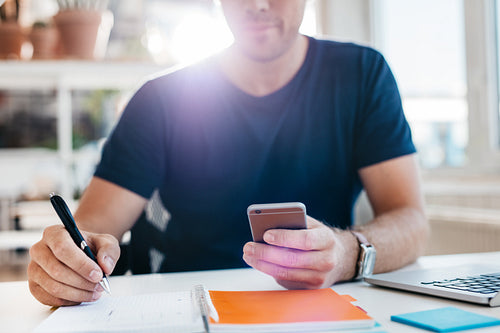 Businessman using mobile phone while working in office
