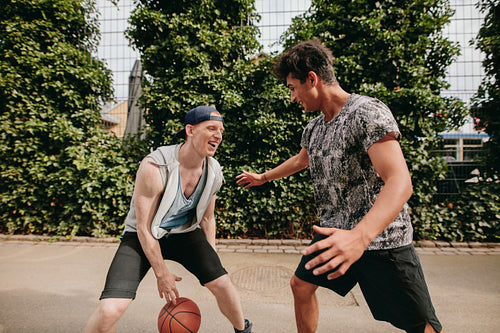 Friends playing basketball on court