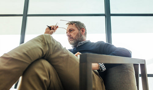 Psychotherapist sitting on arm chair in his office