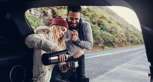 Couple on road trip having coffee break