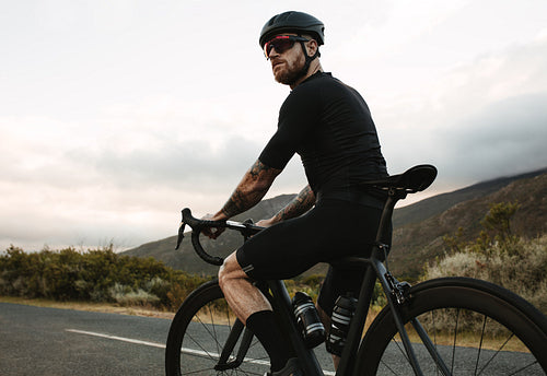Cyclist with a bike on mountain road