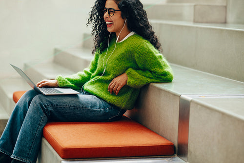 Her online class begins as the student works on a laptop in the library