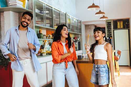Happy family singing together in a colorful and modern kitchen setting