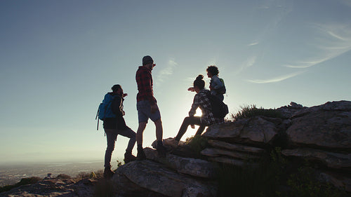Friends relaxing on mountain top during hike