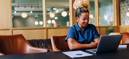 Young woman working on a laptop in a stylish office environment