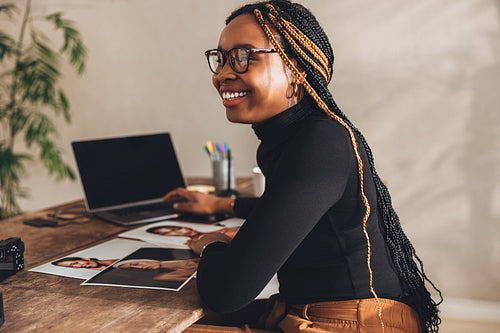 Happy female photographer smiling in her home office