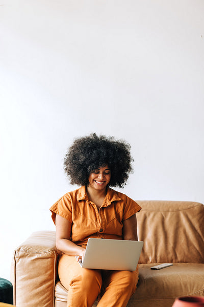 Happy young businesswoman smiling while working on a laptop