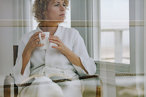 Woman reading a book holding a coffee cup