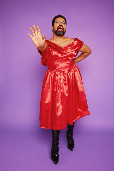 Gender fluid model in shiny dress singing in studio