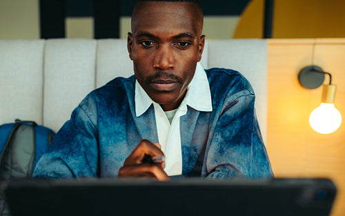 Focused male student studying in a library, concentrating on his work with determination