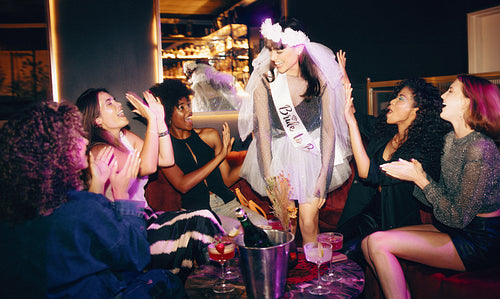 Bride-to-be celebrating with friends a fun evening bachelorette party with drinks