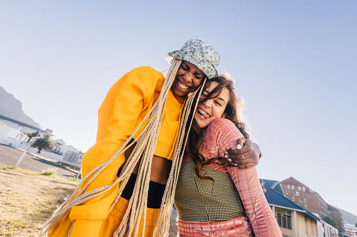 Best friends laughing and embracing each other