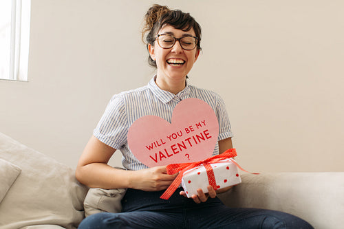 Cheerful woman with valentines card and gift