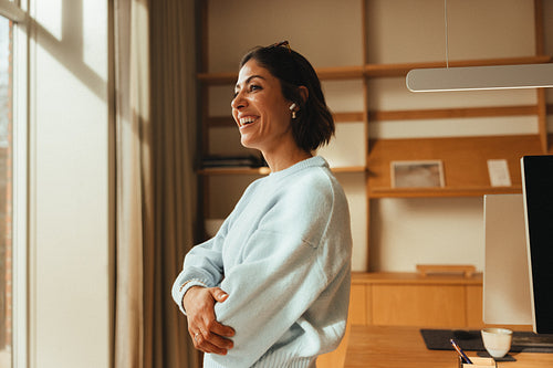 Arms crossed and smiling, confident woman in a bright office