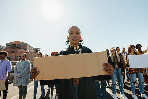 Young woman leading a group of protestors holding signs at a rally