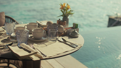 Luxurious breakfast table for three set over the turquoise waters of a tropical resort