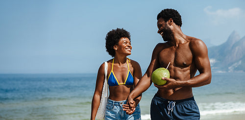 Joyful couple enjoying a beach vacation in summer swimwear