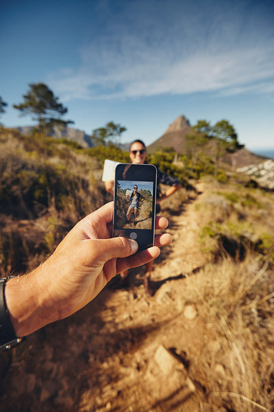 Man talking pictures of a woman with mobile phone - Hiking trip