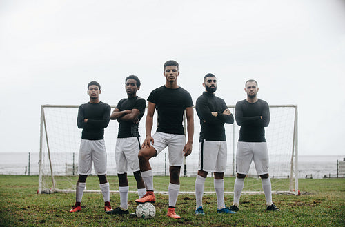 Soccer players standing in front of goalpost