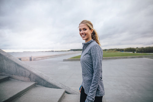 Fitness woman standing outdoors and smiling