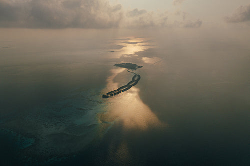 Aerial view of Maldives islands resort with scenic sunset reflections over the ocean