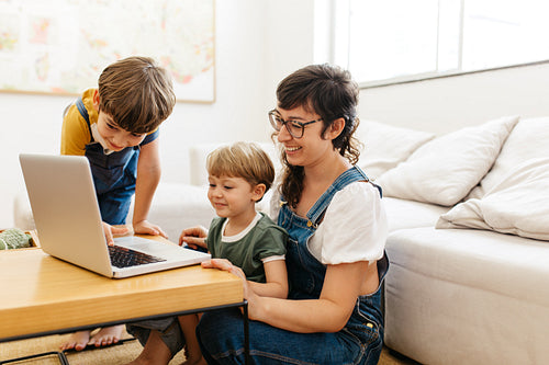 Cute young family looking at a laptop together while at home