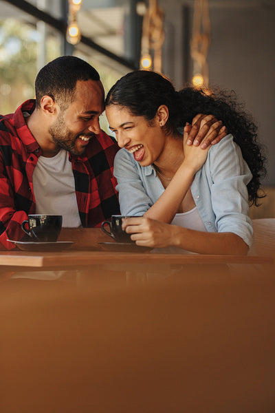 Couple in love talking and smiling in a cafe