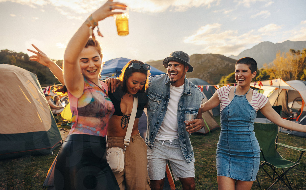 Happy friends groove and celebrate together at a a music festival ...