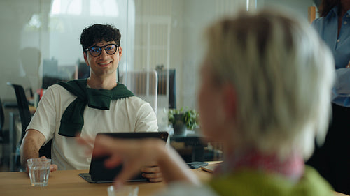 Coworker listens during a business meeting with team in a bright office