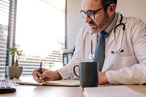 Doctor at clinic writing in his diary