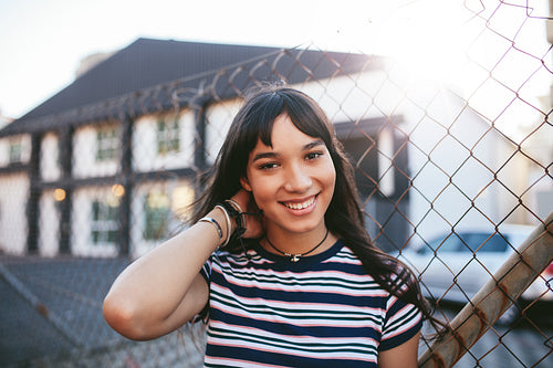 Beautiful young woman standing outdoors and smiling