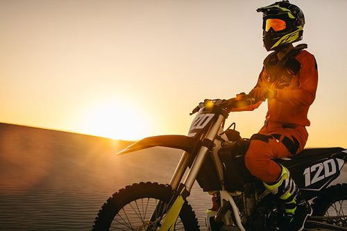 Motocross biker racing on the sand dunes