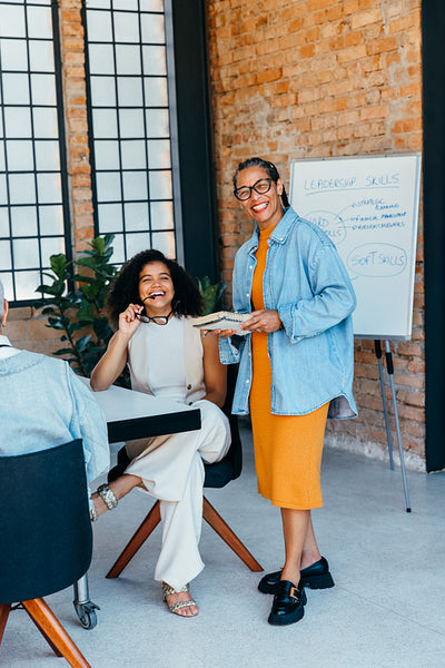 Successful businesswomen collaborating in a meeting room demonstrate teamwork and leadership skills in a sophisticated business environment