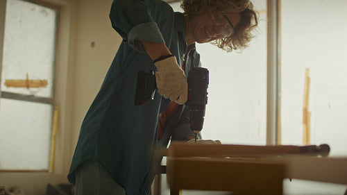 The power of tools: Woman uses a drill to enhance her living space