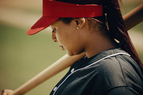 Focused women's league batter preparing for a baseball game with determination and skill
