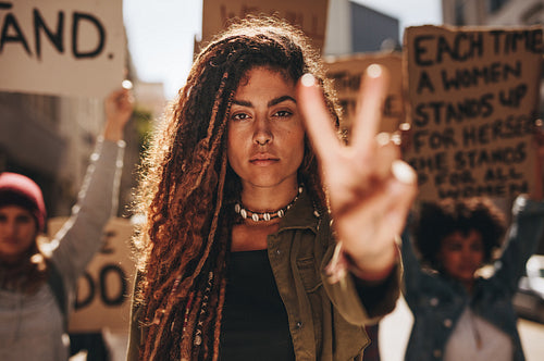 Woman showing a peace sign during protest