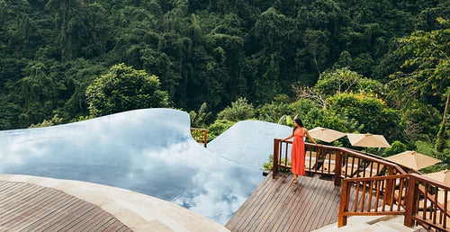 Woman near infinity swimming pool in nature