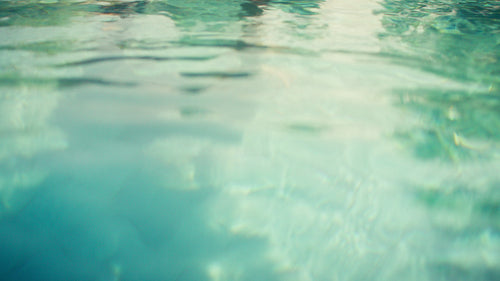 Joyful mother and daughter playing happily in a luxurious resort swimming pool during vacation