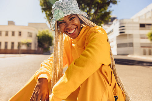 Happy young woman sitting outdoors in the city